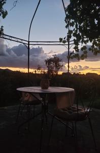 a table and chairs with the sunset in the background at La Tenuta Del Conte in Vignanello
