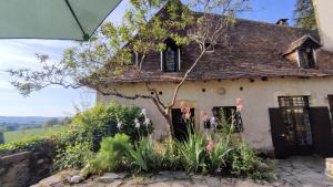 una casa vieja con flores delante en La Fontaine du Mas, en Thiviers