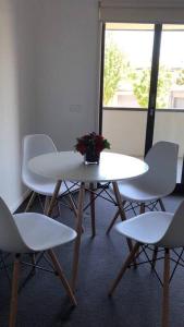 北克莱顿适合家庭/出差朋友的安静舒适整套公寓entire APT for holiday rental的一组白色椅子和一张桌子,上面有花
