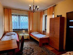 a bedroom with two beds and a table and a window at Hostel MOC in Warsaw