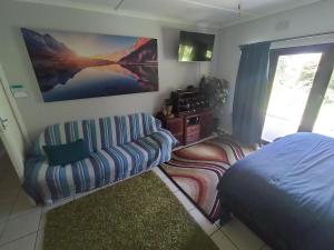 a living room with a couch and a bed at Casa Ariel - River Lodge in Port Edward