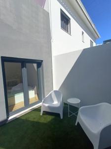 a patio with a white chair and a table at Casa Saudade in Charneca