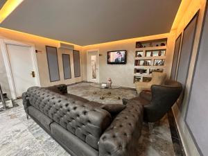 HARRAN HOTEL في إسطنبول: غرفة معيشة مع أريكة كبيرة وتلفزيون