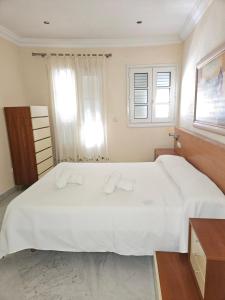 a bedroom with a large white bed with towels on it at Duplex centro Lidia in Ronda