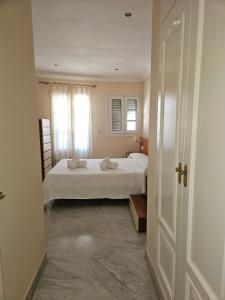 a bedroom with a white bed and a window at Duplex centro Lidia in Ronda