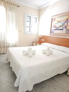 a bedroom with a large white bed with towels on it at Duplex centro Lidia in Ronda