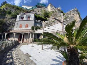 Idillioravello في رافيلو: مبنى على جانب جبل فيه نخلة