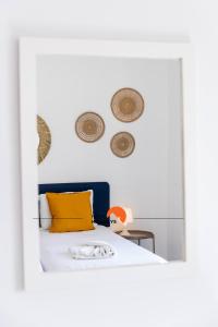 ein Schlafzimmer mit einem Bett mit gelbem Kissen und einem Spiegel in der Unterkunft #189 Montechoro Flat by Home Holidays in Vale de Pedras