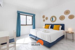 ein Schlafzimmer mit einem blau-weißen Bett und einem Fenster in der Unterkunft #189 Montechoro Flat by Home Holidays in Vale de Pedras + 40 Fotos