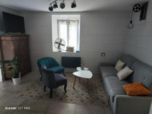 a living room with a couch and a table at Appartement rénovée dans maison ancienne in Amancy