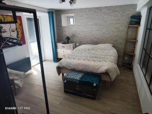 a bedroom with a bed and a brick wall at Appartement rénovée dans maison ancienne in Amancy