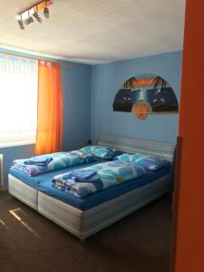 - une chambre avec un lit dans une pièce bleue dans l'établissement Housing HELLA, à Nová Lesná