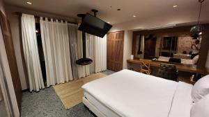 1 dormitorio con 1 cama blanca grande y TV en Barry Hotel, en Izmir