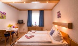 1 Schlafzimmer mit 2 Betten, einem Tisch und einem Fenster in der Unterkunft Draxlerhaus in Hohentauern