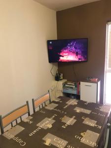 d'une salle à manger avec une table et une télévision à écran plat. dans l'établissement Housing HELLA, à Nová Lesná