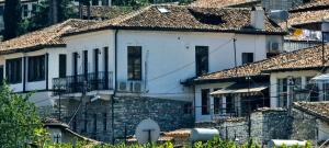 ein weißes Haus mit Ziegeldächern in einem Dorf in der Unterkunft Hotel Gorica - UNESCO quarter in Berat