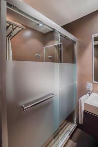 a glass shower in a bathroom with a sink at Hotel Constanza in Barcelona