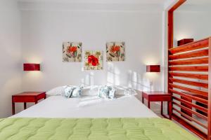 ein Schlafzimmer mit einem weißen Bett und zwei roten Bänken in der Unterkunft Casa DV Suites Gold Standard Certified in Caye Caulker