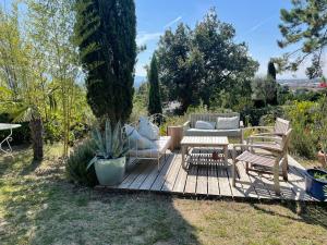 a wooden deck with a table and chairs in a yard at La Sauveterre in Mours-Saint-EusÃ¨be