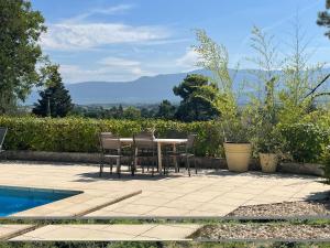 a patio with a table and chairs next to a pool at La Sauveterre in Mours-Saint-EusÃ¨be