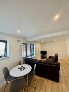 a living room with a black leather couch and a table at Overlooking city centre apt in Waterford