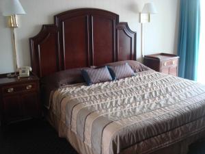 a bedroom with a large bed with a wooden headboard at Harbor Base Inn in Newport