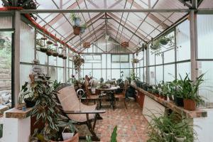 a greenhouse with a table and chairs and plants at Shepherds Ridge powered by Cocotel in Mabitac
