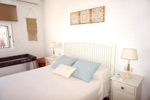 サンルーカル・デ・バラメダにあるVilla Horaciaのベッドルーム(白いベッド、青い枕付)