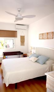 サンルーカル・デ・バラメダにあるVilla Horaciaのベッドルーム(白いベッド1台、天井ファン付)