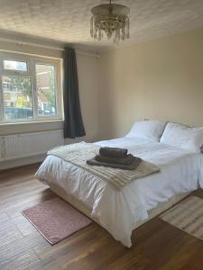 a bedroom with a large white bed with a chandelier at Single and doubles rooms close to central London in London