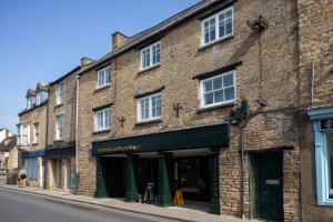 un edificio di mattoni con un tendone verde su una strada di 30 Chipping Norton - Luxury Holiday Apartments a Chipping Norton