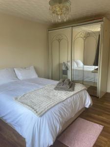 a bedroom with a large white bed with a mirror at Single and doubles rooms close to central London in London