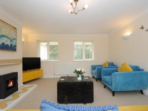 a living room with blue furniture and a fireplace at Minack in Bude