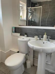 a white bathroom with a toilet and a sink at Single and doubles rooms close to central London in London