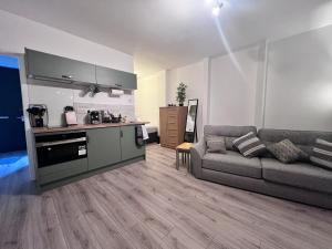 ein Wohnzimmer mit einem Sofa und einer Küche in der Unterkunft Beddoes Court Top Floor Studio with Sea Views in Saundersfoot