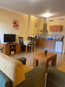 een woonkamer met banken en een keuken bij Apartamentos María Del Carmen in Torremolinos