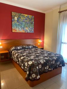 1 dormitorio con 1 cama y una pintura en la pared en Apartamentos María Del Carmen, en Torremolinos