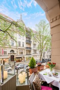 a balcony with tables and chairs on a city street at Hotel Augusta Am Kurfürstendamm in Berlin