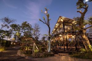 a tree house with lights on it at night at Na Klongluang Boutique Resort in Ban Khlong Nung