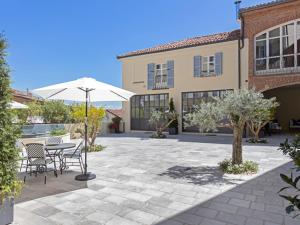 een patio met een tafel en een parasol bij La Casa dei Fortunati in Montemagno