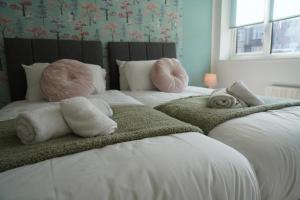 a bedroom with two beds with towels on them at Cosy 2 bedroom on Bromley-Lewisham Hospital Borders in Catford