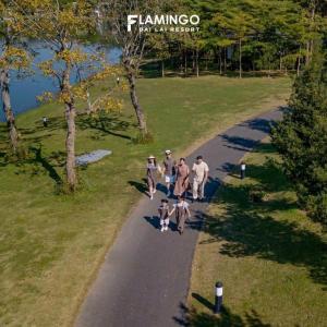 um grupo de pessoas caminhando por um caminho em um parque em Flamingo Happy Villa Owner em Ngọc Quang