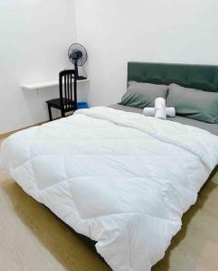- un grand lit blanc avec un animal rembourré dans l'établissement Cheerful 27 Home with BBQ grill, à Cheras
