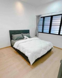 1 dormitorio con 1 cama blanca grande y ventana en Cheerful 27 Home with BBQ grill en Cheras