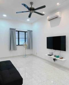 sala de estar con ventilador de techo y TV de pantalla plana en Cheerful 27 Home with BBQ grill en Cheras