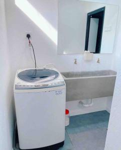 a bathroom with a sink and a washing machine at Cheerful 27 Home with BBQ grill in Cheras