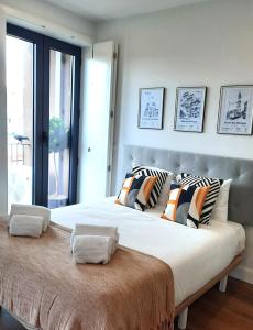 een groot bed met kussens in een slaapkamer bij Smiling Places - Apartment in Porto in Porto