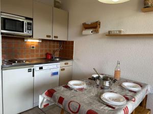 eine kleine Küche mit einem Tisch mit Tellern darauf in der Unterkunft Appartement Montgenèvre, 2 pièces, 6 personnes - FR-1-330D-70 in Montgenèvre