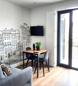 a dining room with a table and a tv on a wall at Smiling Places - Apartment in Porto in Porto