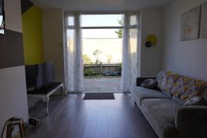 a living room with a couch and a large window at Our 2 bedroom house or borders of Bromley and Lewisham is available now! in Catford